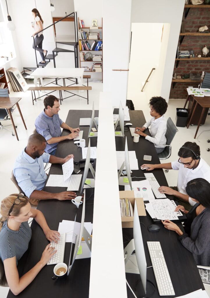 Colleagues Working At A Busy Open Plan Office PQMUBW3 1 722x1024